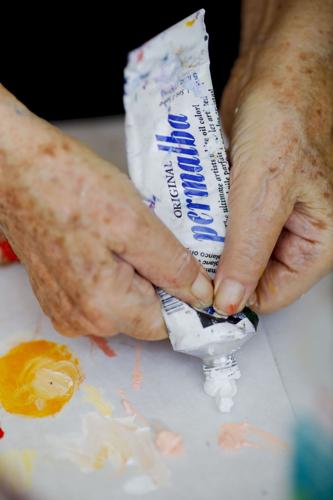hands squeezing white oil paint