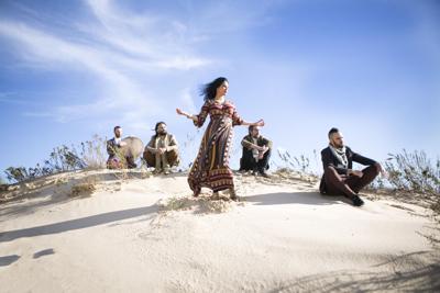 Five musicians standing in a desert
