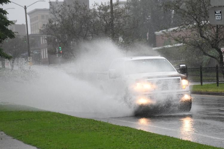 An SUV splashes through a puddle