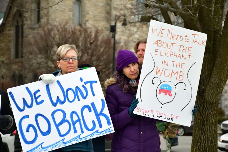 Two women hold signs at a rally