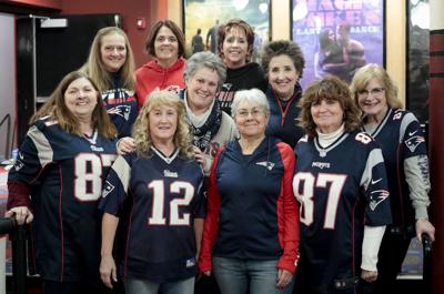 group of women in patriots jerseys at movies