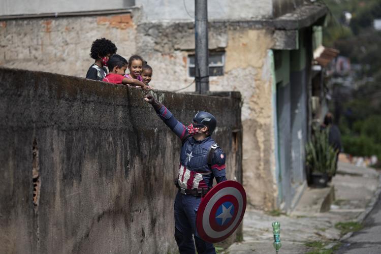 An officer dressed as a superhero speaks to children