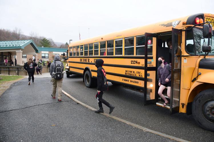 Students get off the buses and go into school