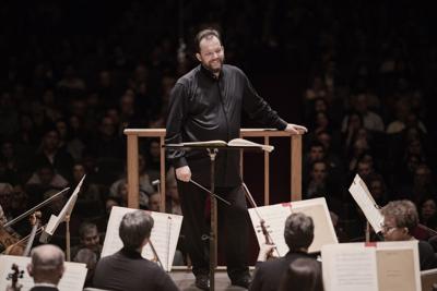 Conductor stands in front of an orchestra