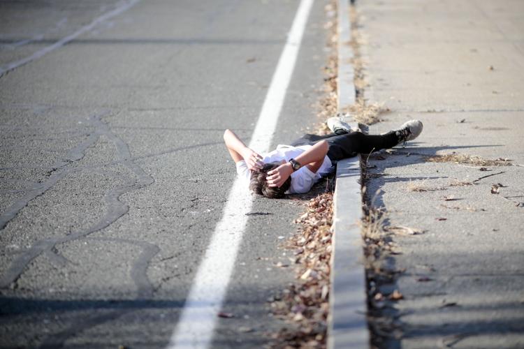 Zachary Paredes lies down on road after running race