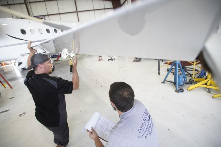 mechanics inspect a wing