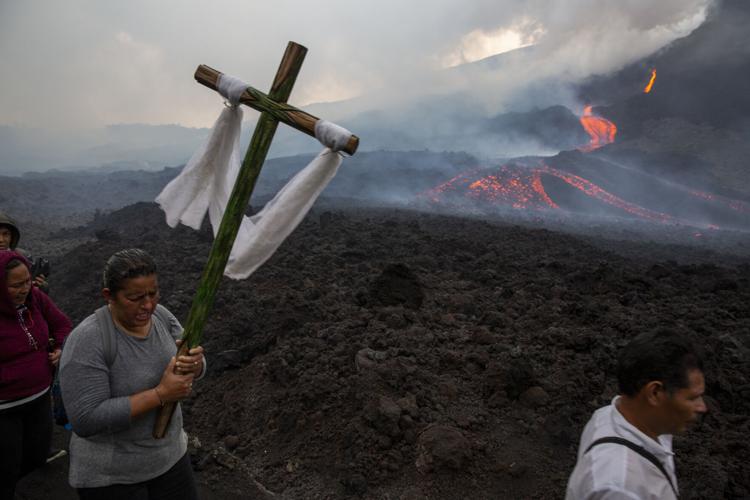 A woman carries a cross during a pilgrimage