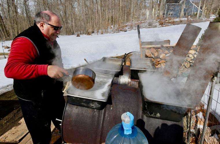 Man boils sap on an outdoor stove