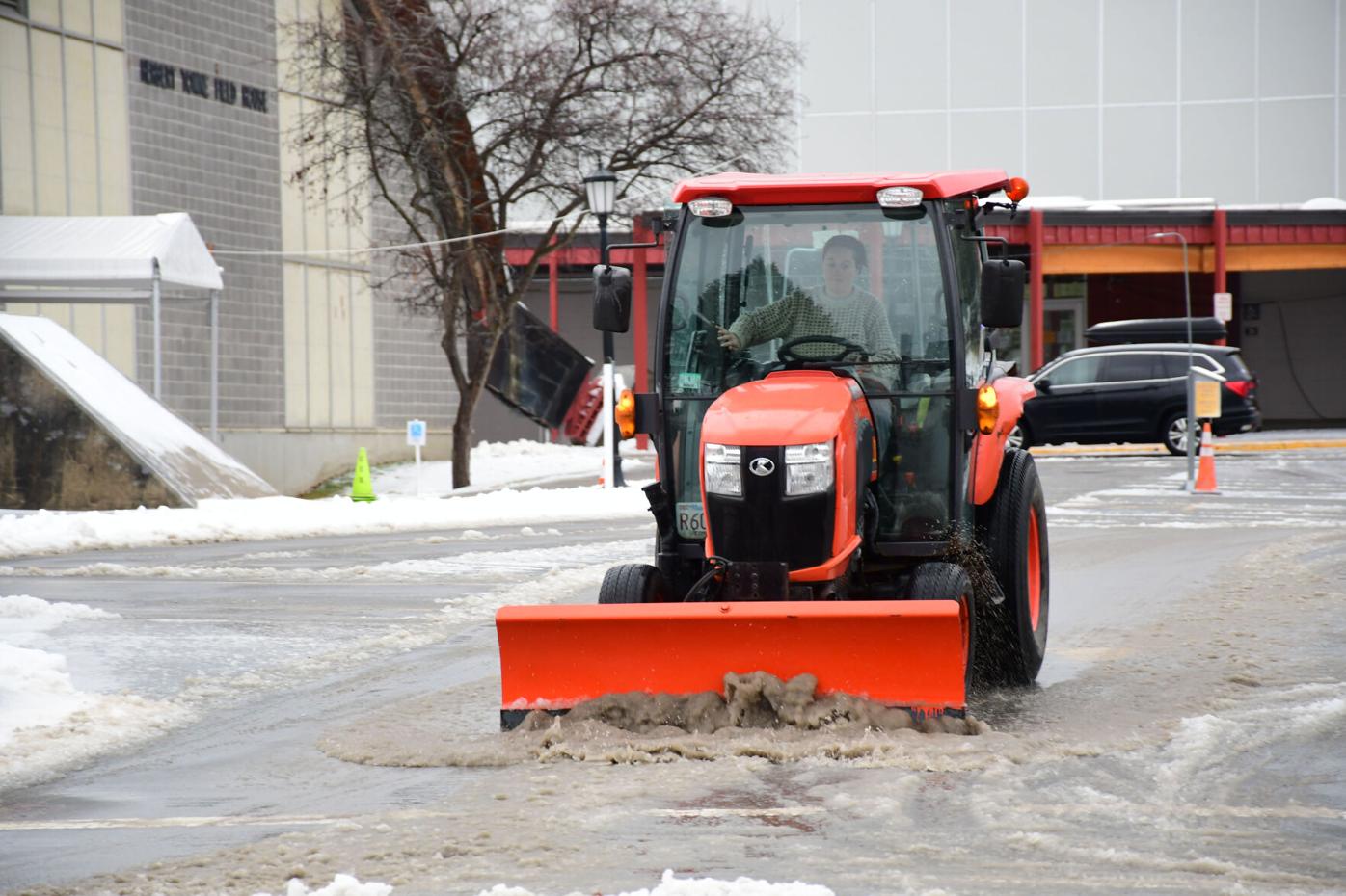 A plow moves melted snow
