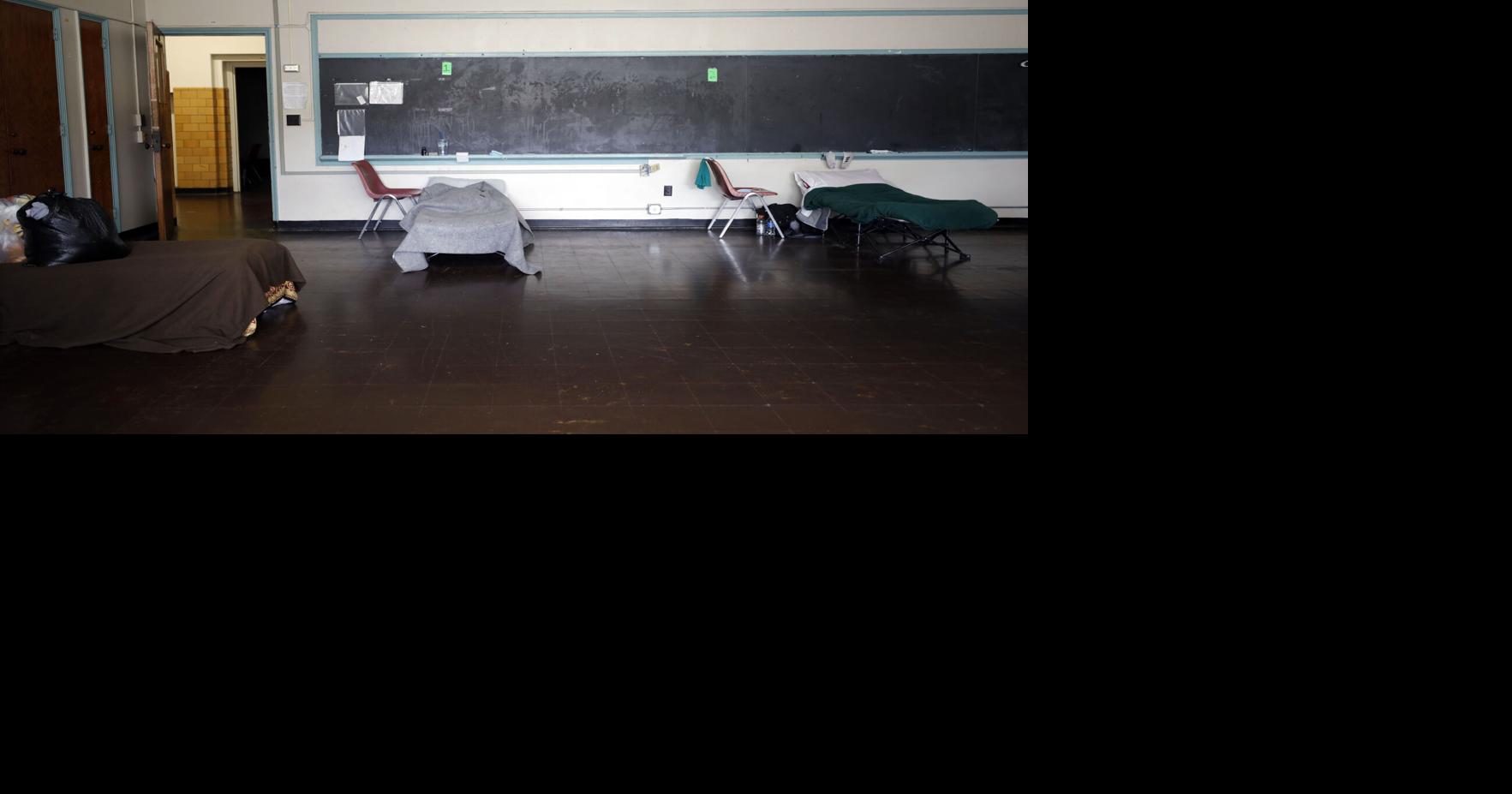 cots set up in classroom with blackboards
