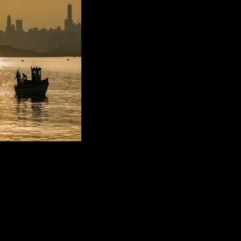 A fisherman pulls his net from the Mediterranean Sea on a trawler off Dbayeh near Lebanon's capital Beirut
