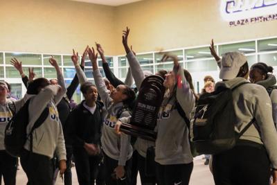 Women's hoops celebrating after arrival home