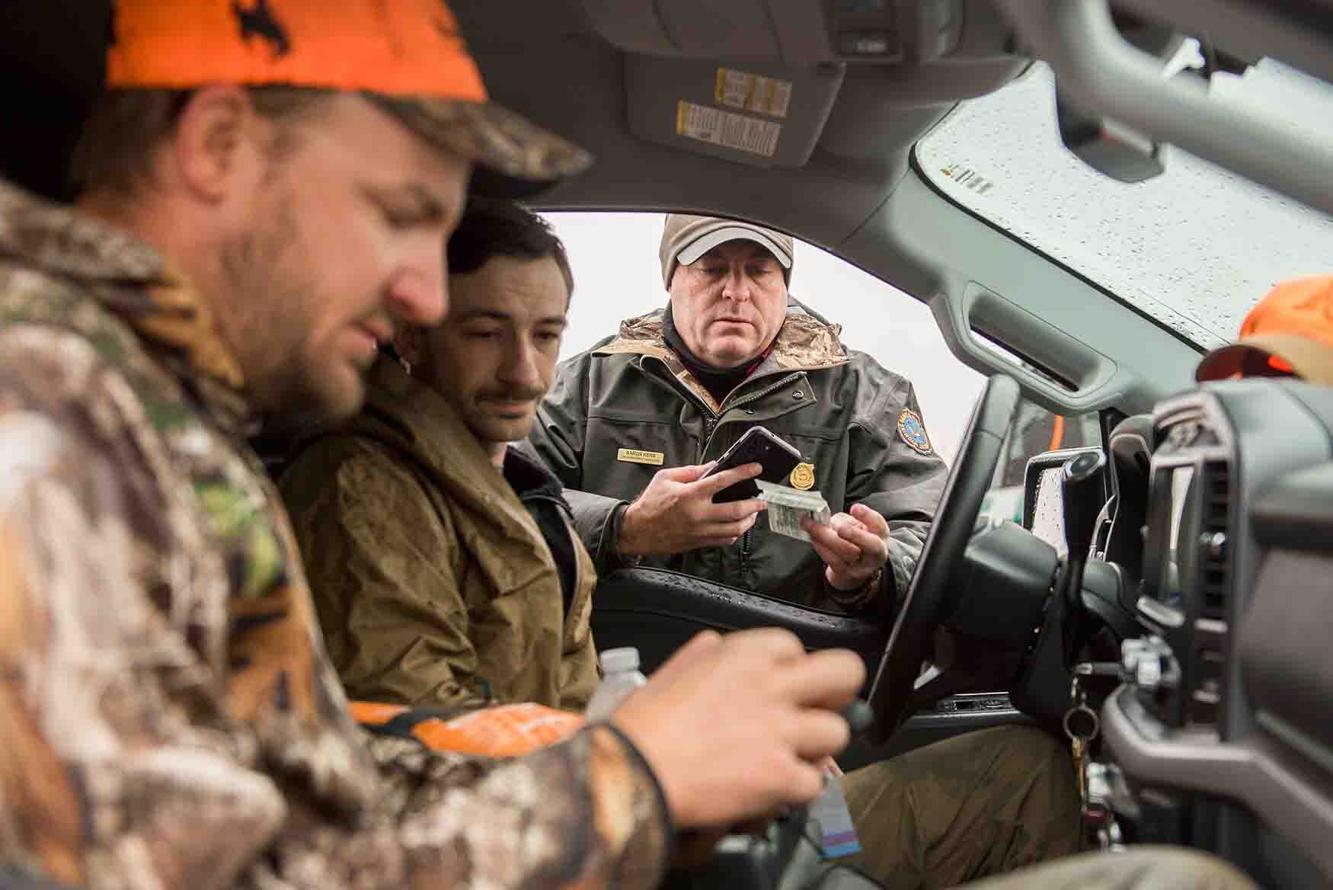 Aaron Kerr, law enforcement supervisor, checks hunter license