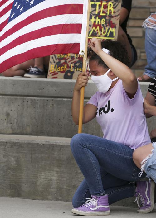 Danica Boyce, 16, fights tears as she holds the U.S. Flag during a moment of silence