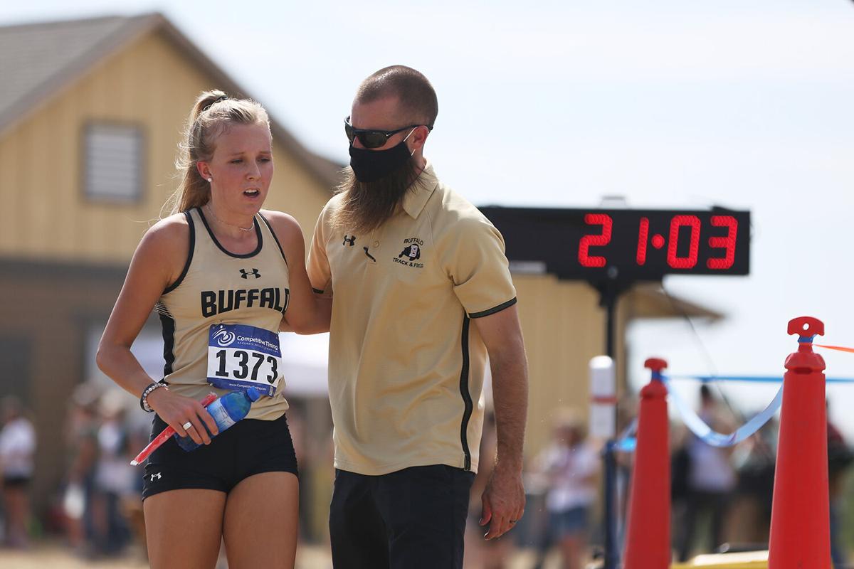 Activities Director Ryan Mader hugs an congratulates Buffalo High School’s first finisher Kendall Tietjen