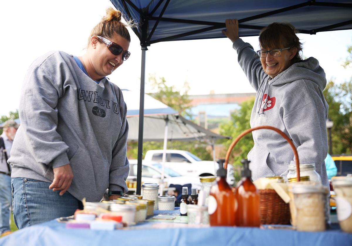 Tammy Schick, left, laughs as she looks through Amy Helvik’s bath and home products