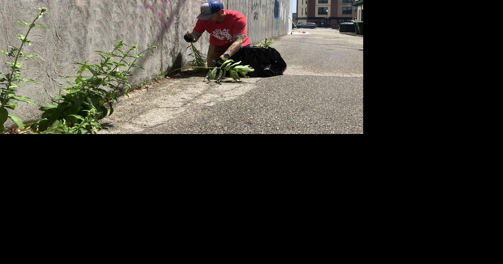 Artist beginning work on alleyway mural in Cadillac