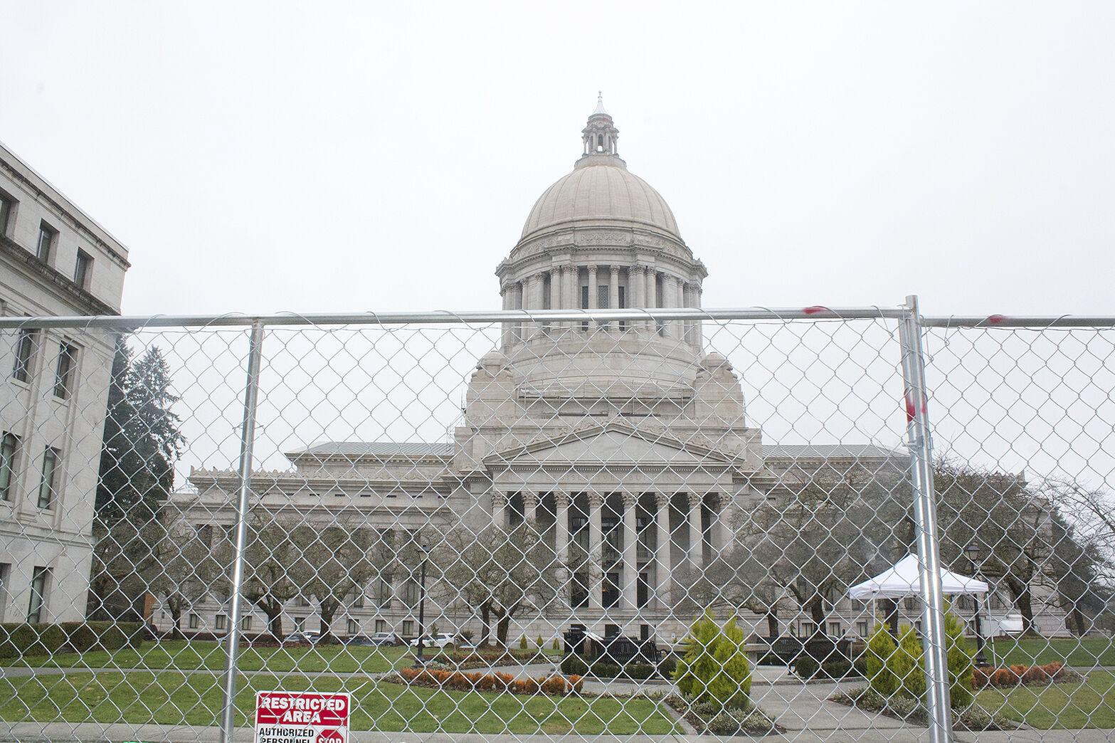 A picture of the Washington state capitol behind a steel fence 
