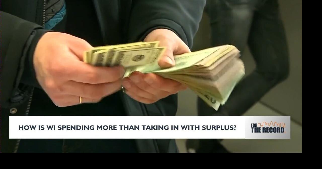 How is WIsconsin spending more than taking in with surplus?