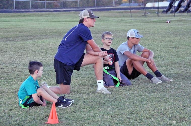 Football players volunteer for little league coaching People