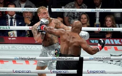 Jake Paul (left) backs Mike Tyson onto the ropes in their eight-round fight in Texas on Friday