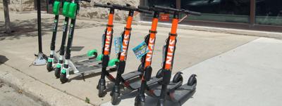 Electric Scooters parked and ready for rental on the city’s west side. Photo by Angela Gagnon