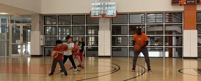 Coach Brian Harris teaches kids ball handling skills during the basketball classes at LSF. Photo by Angela Gagnon