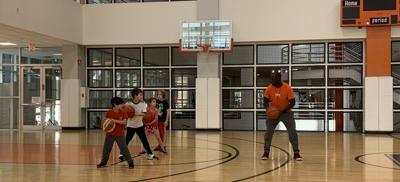 Coach Brian Harris teaches kids ball handling skills during the basketball classes at LSF. Photo by Angela Gagnon