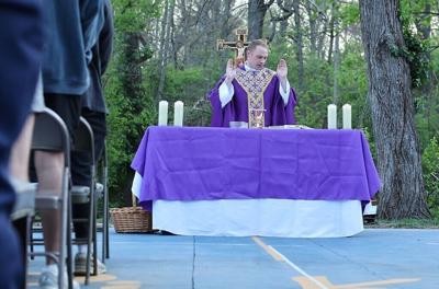Fr. Andrew blesses communion at the altar during outdoor Mass at Pi Kappa Phi