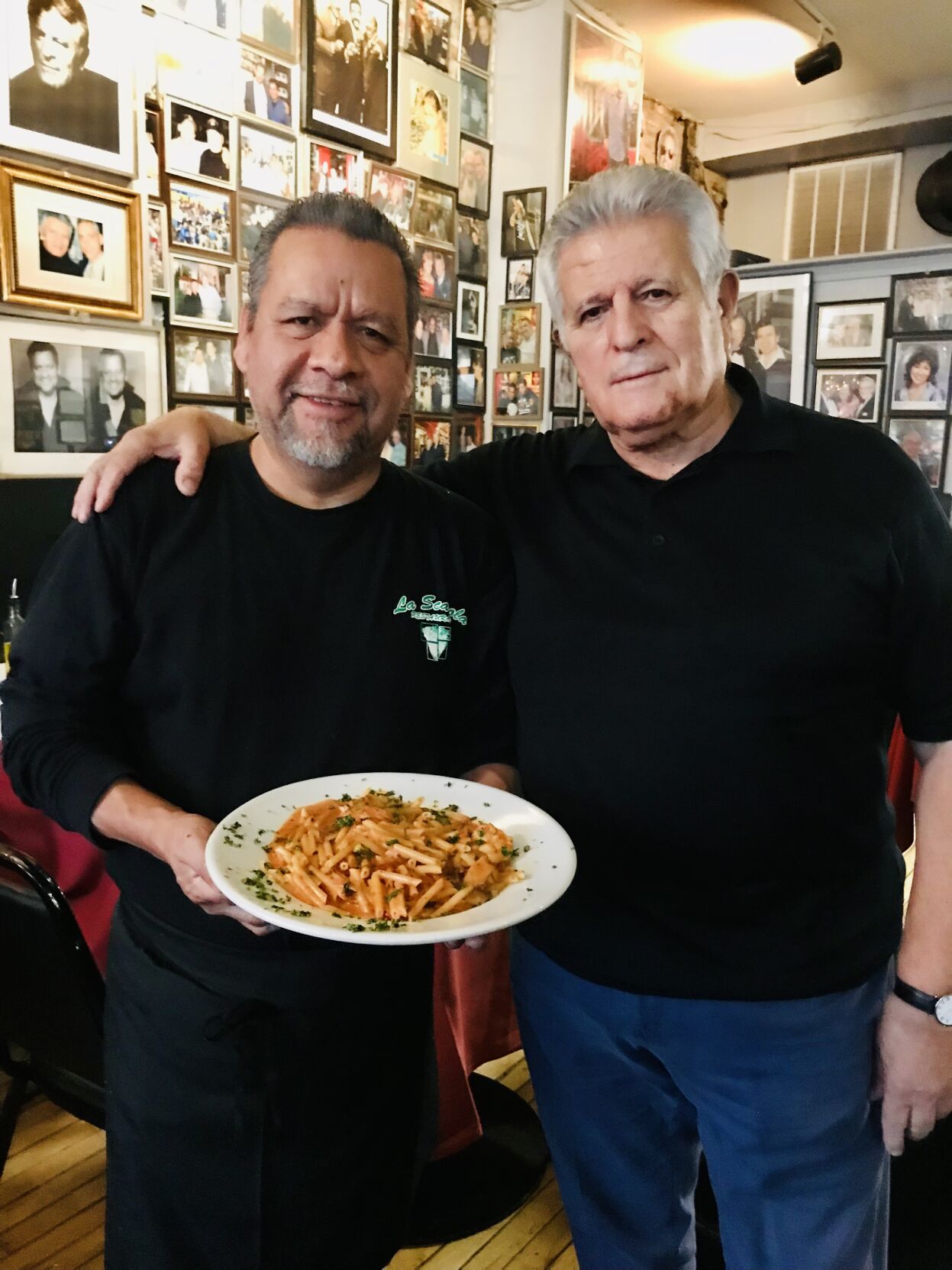 La Scarola owners Armando Vasquez and Joey Mondelli holding a house-made pasta dish. (Photo by Candace Jordan)
