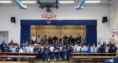 Passport Auto Group employees and Panorama Elementary School students and staff stand together after the bike donation ceremony.