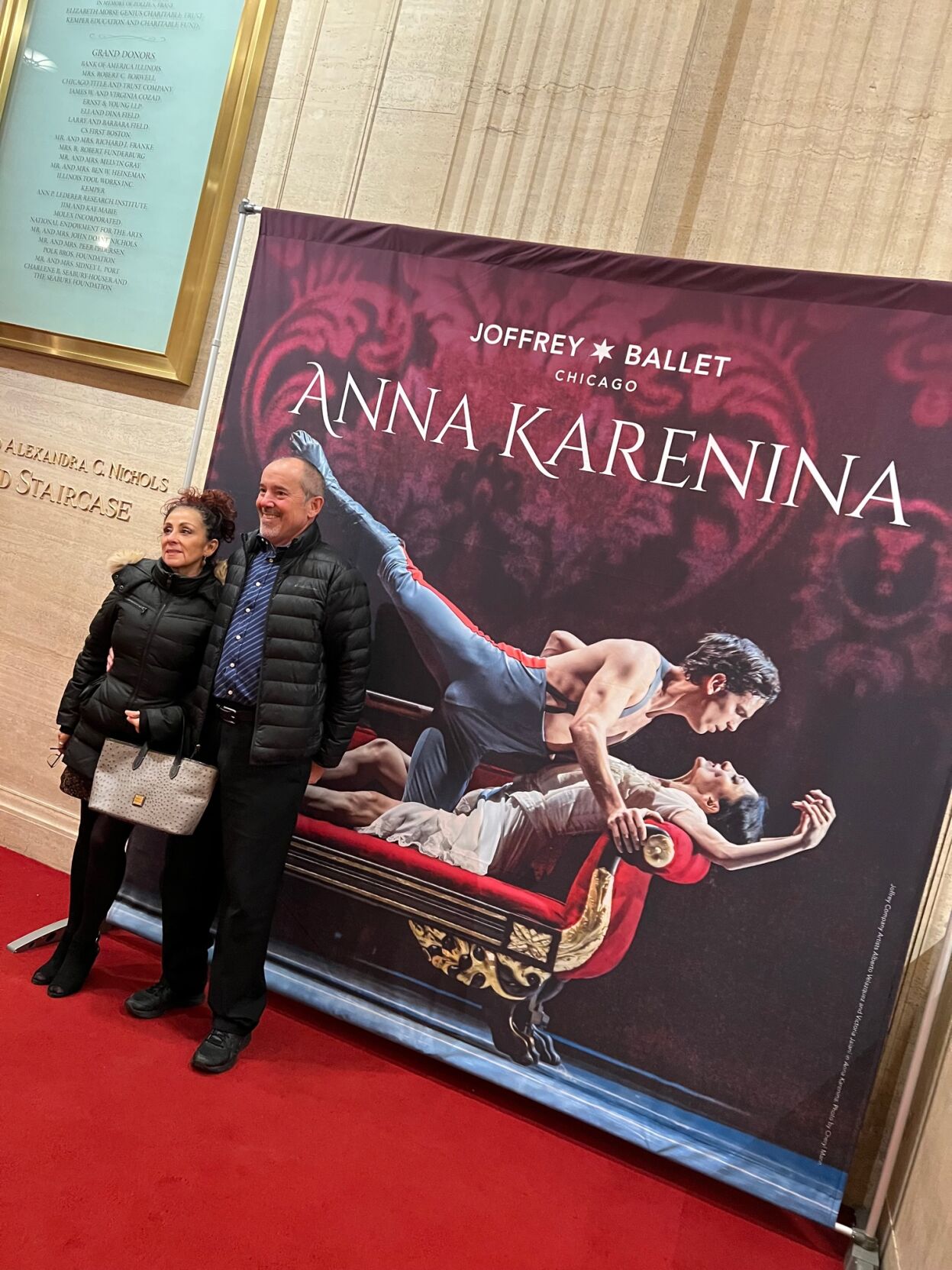 Guests posing by Anna Karenina banner in lobby of the Lyric Opera House.
