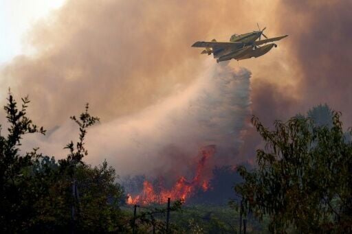 A plane dumps water on a wildfire west of Madrid on July 26, 2026