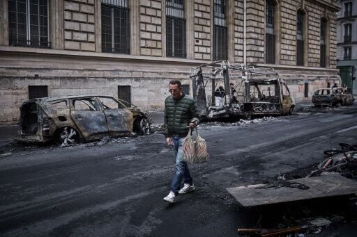 Burnt-out vehicles line a Paris street on Monday