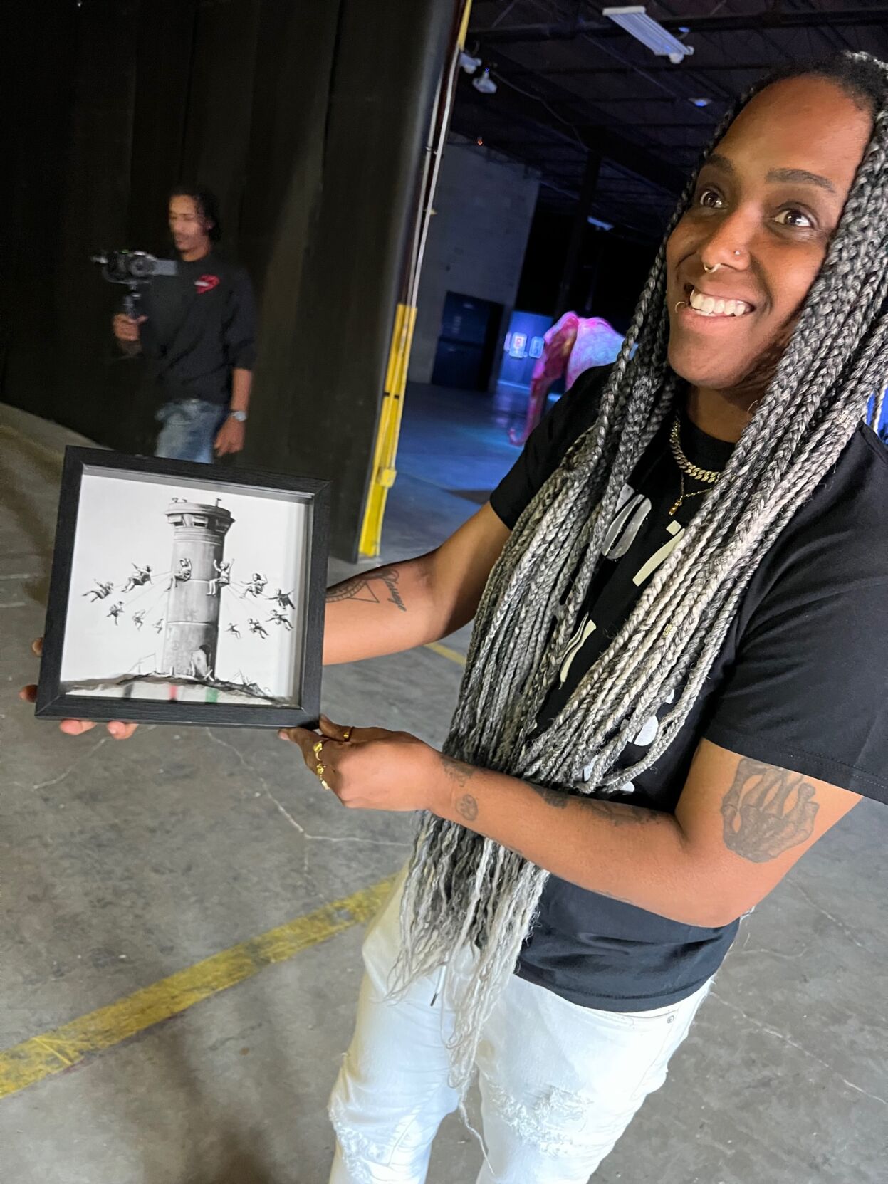 Lumio Studio producer, Brittany, shows off original Banksy artwork purchased at the Walled-Off Hotel in Palestine. (Photo by Candid Candace Jordan)
