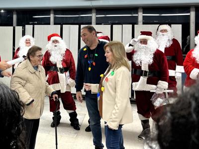 Mary Ellen Harris speaks with Patti and Matt Dickins of the RAINE Foundation during their annual Santa Run.