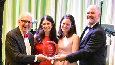 Dr. Eric Kandel, left, accepnts a lifetime achievement award with his granddaughters at the National Headach Foundation’s annual gala