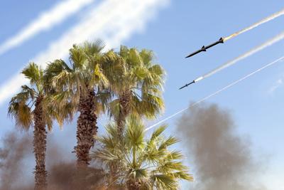 Ballistic missiles in the sky on the background of palm trees, traces of missile launch. Concept: war between Iran and Israel, missile attack. (Photo Wikimedia Commons)