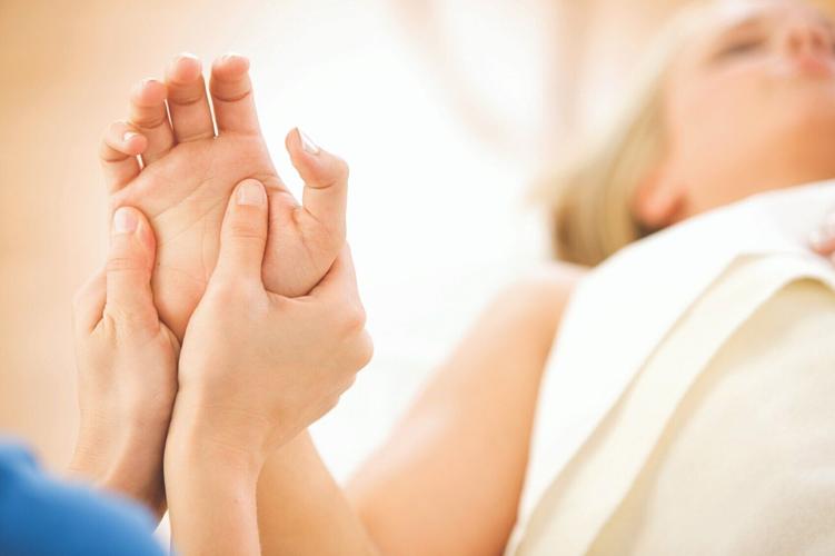 A woman receiving massage therapy in a clinical setting.