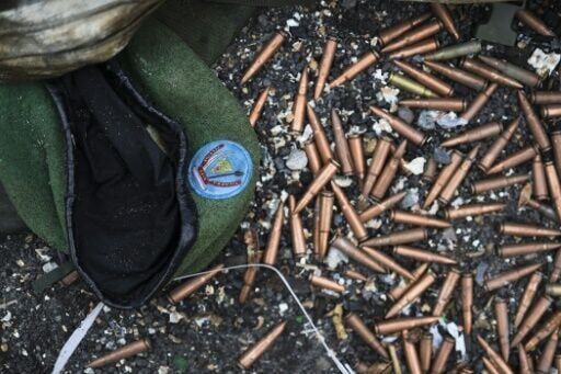 A crumpled Congolese army beret alongside cartridges near an abandoned, bullet-riddled military truck in Goma