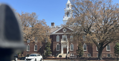 Brick building with white bar out front and white spiel on top