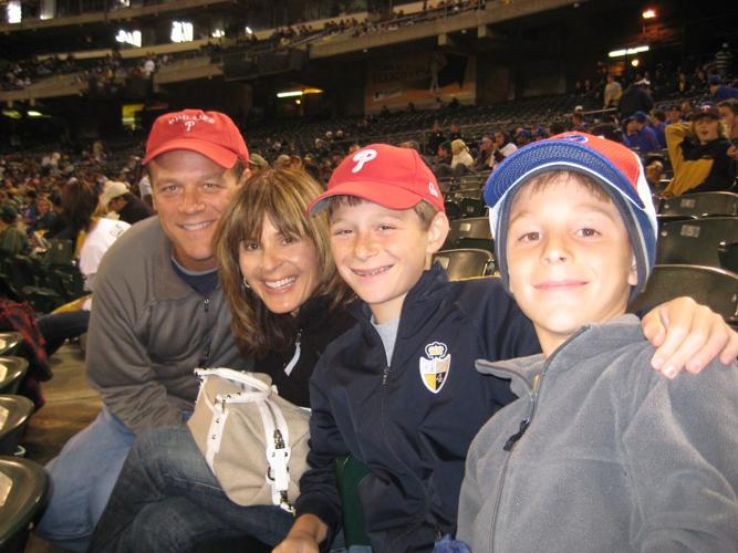 nicole and her family smile at a baseball game