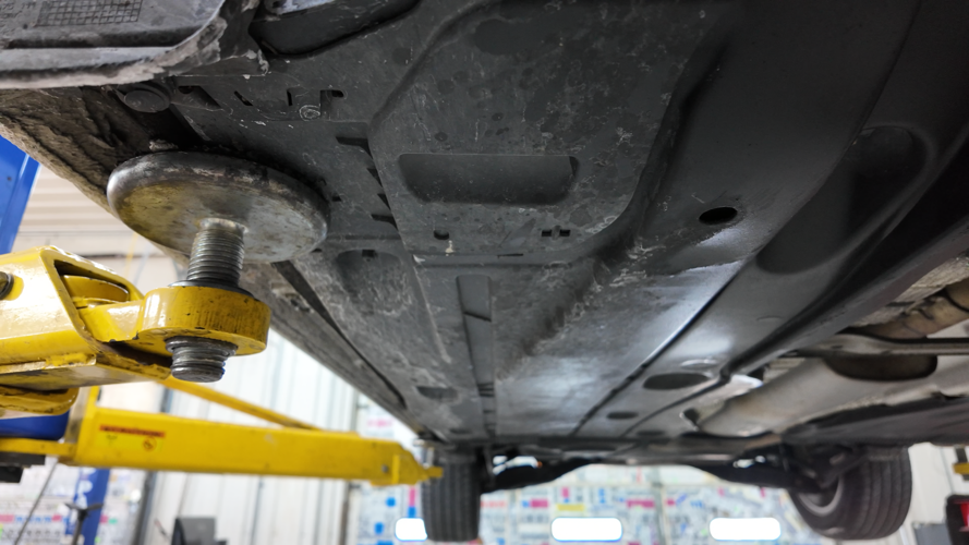 Underneath a car covered in salt.