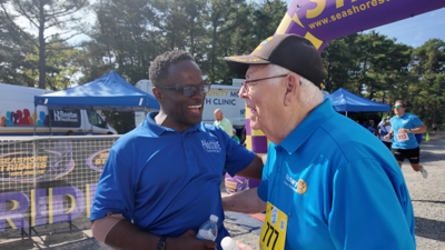 Paul Williams and a participant of the walk crossing the finish line.