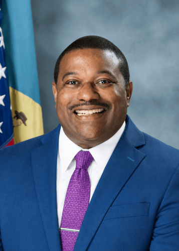Man posing for headshot in blue suit and purple tie