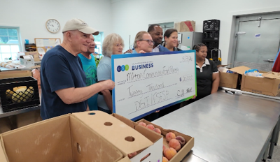 people holding a large check for 20 thousand dollars