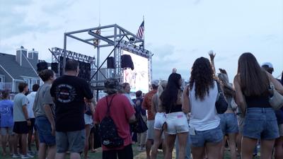 Crowds cheering while fishes are being weighed.