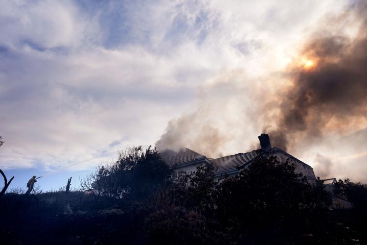 Photos show wildfire fueled by high winds engulfing coastal homes in Southern California