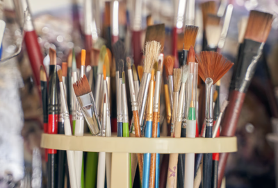 a close up shot of paint brushes and art supplies 