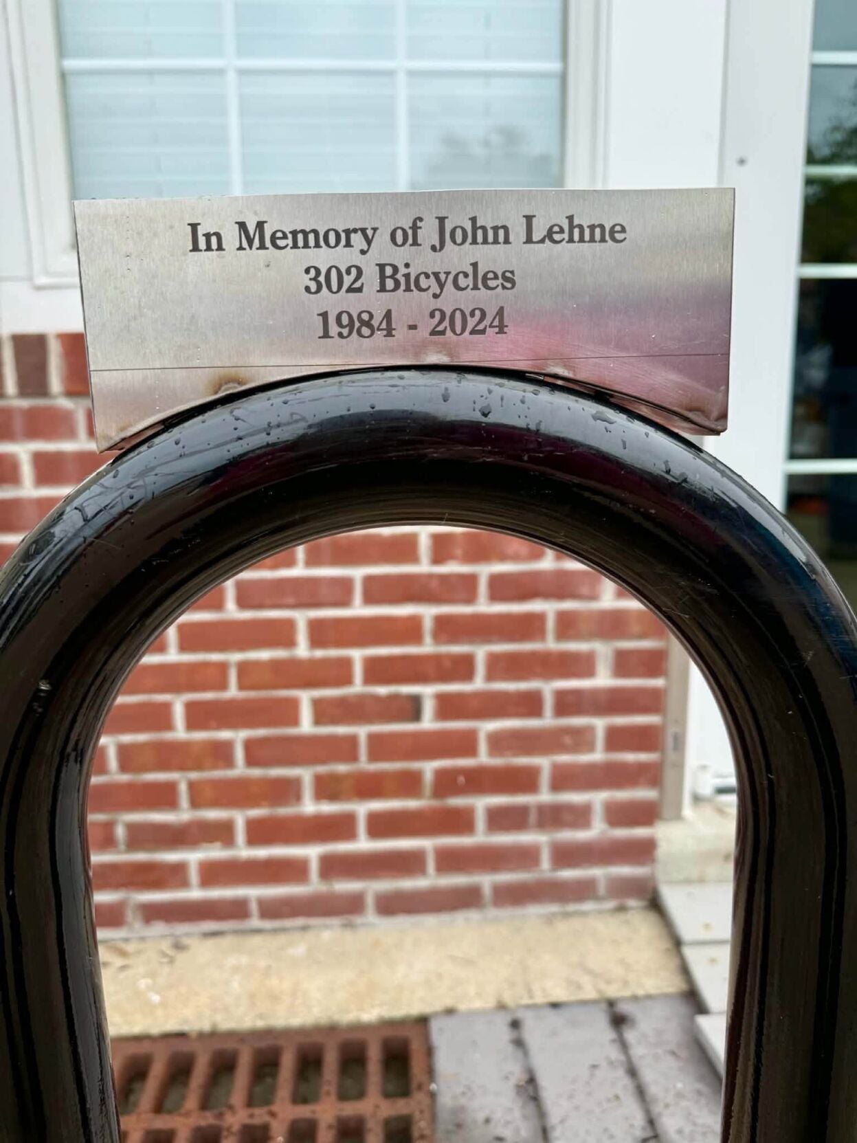 A plaque dedicating a bike rack.